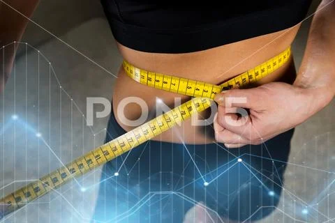 Close up of woman measuring waist by tape in gym Stock Photos