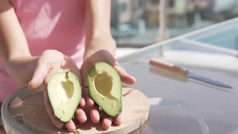 Close-up, a woman opens a ripe avocado cut in half Stock Footage 235048823