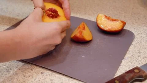 Close up woman peeling and slicing peaches Stock Photos