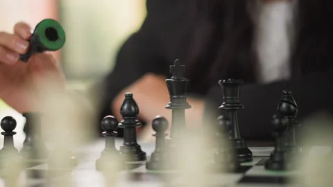 Close up of woman playing chess moving black pieces on board with soft focus and Stock-Footage 346649574