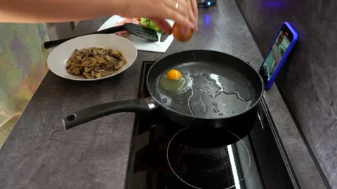 Close-up of a woman preparing breakfast scrambled eggs in the kitchen Stock Footage 204070837