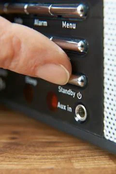 Close up of woman pressing standby button on radio Stock Photos