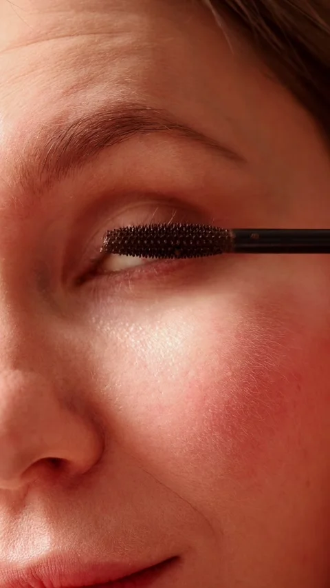 Close up of woman pulling mascara brush out of tube Stock Footage 329613321