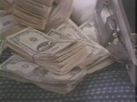 Close-up of woman putting stacks of money into suitcase, 1980s Stock Footage