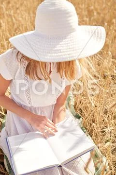 Close up of woman reading book on cereal field Stock Photos