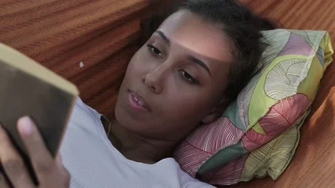 Close up of woman reading book while lying in a hammock in the woods Video stock 143484961