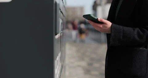 Close up woman receiving parcel from post terminal machine using smartphone. Stock Footage 297762162