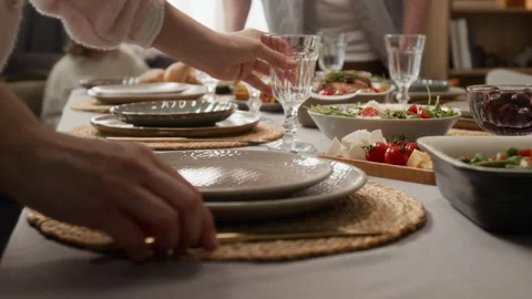 Close-Up of Woman Setting Dining Table with Plates for Family Dinner Stock Footage 340331667