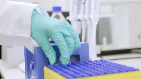 Close up of a woman shaking samples using a vortex mixer before HPLC analysis. Stock Footage 279995679