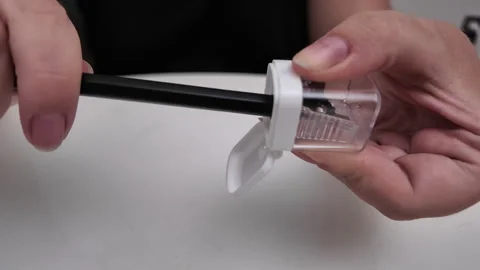 Close-up of a woman sharpening a pencil with a sharpener over a table. Stock Footage 319295683