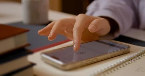 Close up of a woman signing documents using smartphone technology in office Stockfoto's