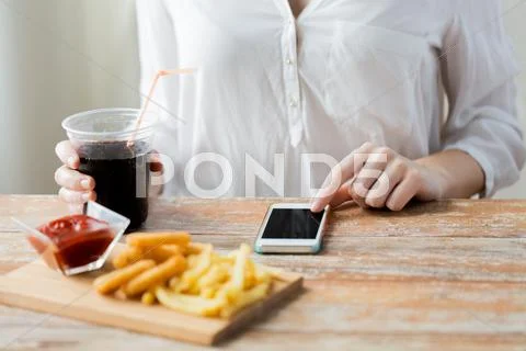 Close up of woman with smart phone and fast food Stock Photos