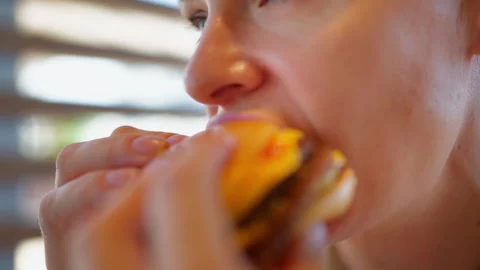 Close-up of woman taking a bite of hamburger and enjoying fast food. Appeti.. Stock Footage 342169796