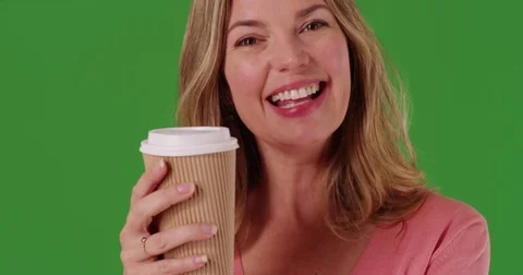Close up of woman talking to camera and drinking coffee or tea on green screen Stock Footage