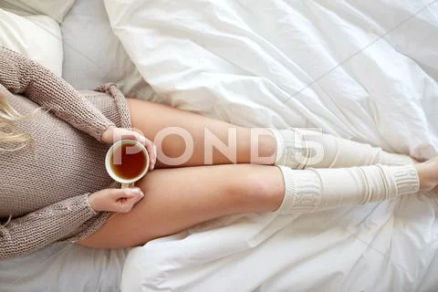Close up of woman with tea cup in bed Stock Photos