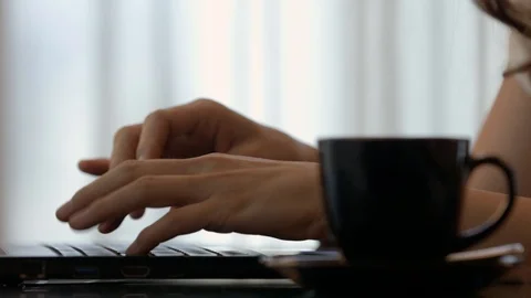 Close-up woman is typing on her computer and drinking coffee Video stock 114795299
