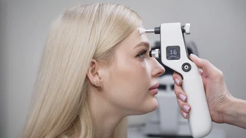 Close-up of a woman undergoing tonometry eye examination with a handheld device Stock Footage 337288462