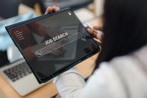 Close up of a woman using a digital tablet for job searching online via a w.. Foto stock
