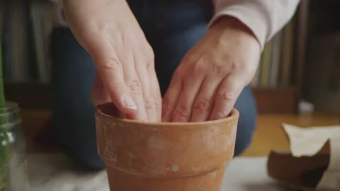 Close up of a woman using her hands to place soil in a pot Video stock 152820325