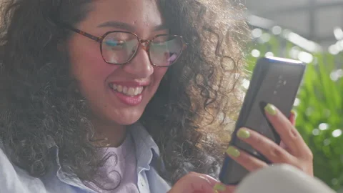 Close up of woman using modern smart phone at home sitting on the sofa enjoying Stock Footage 205850811