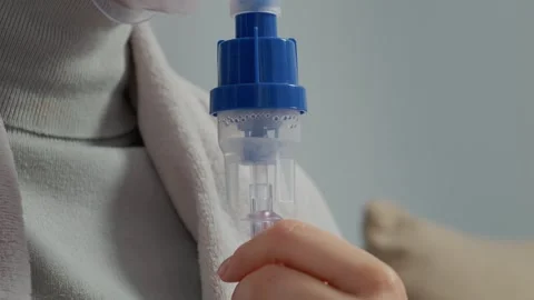 Close up of woman using nebulizer for respiratory treatment and relief Stock Footage 346706106