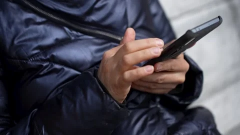 Close-up of woman using phone while sitting on swing Stock Footage 274478809