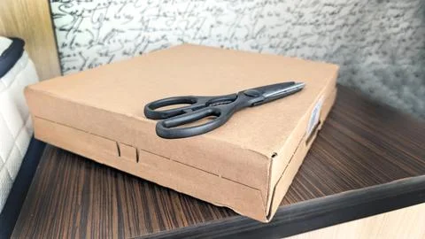 Close Up Of Woman Using Scissors To Open Delivery Parcel Bag Stock Photos
