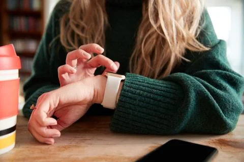 Close Up Of Woman Using Smart Watch Sitting At Table  In Cafe Stock Photos