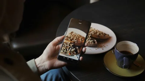 Close-up woman using smartphone camera takes the dessert in a cafe Stock Footage 131447006