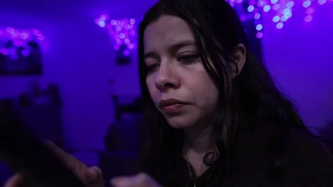Close-up of Woman Using Smartphone in Dim Room with Blue LED Lights at Night Stock Footage 338041696