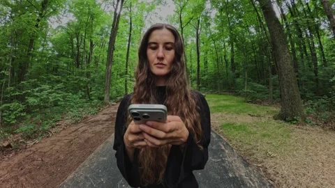 Close-up of a woman using a smartphone during a walk... Stock Footage 339101255