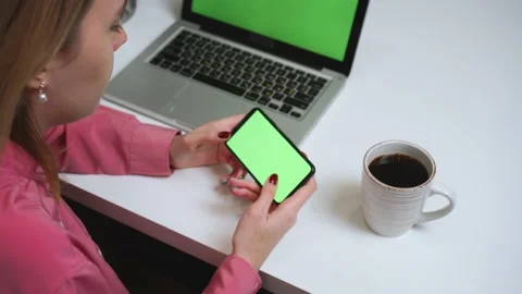 Close up woman using smartphone green screen on the table with laptop computer Stock Footage 145100748