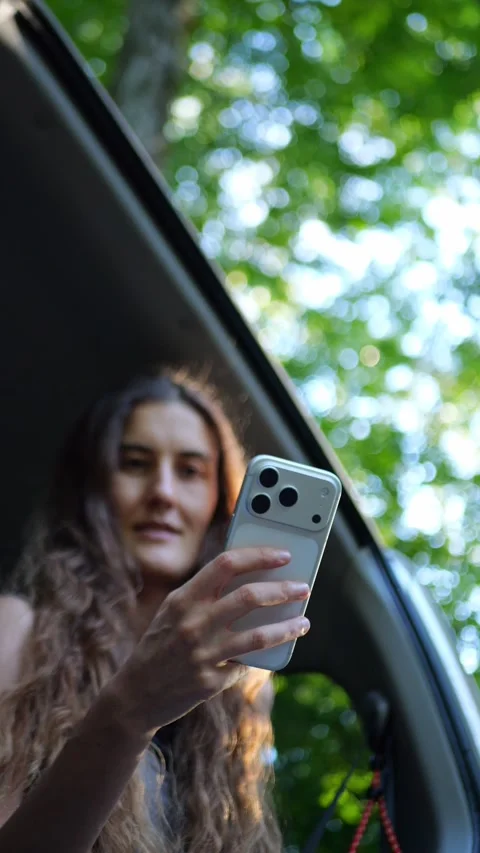 Close-up of a woman using a smartphone inside a car, browsing content... Видео 340291000