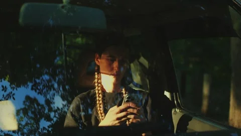Close-up of a woman using a smartphone inside a parked car behind a... Stock Footage 341613084