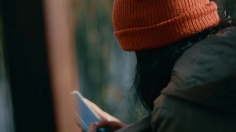 Close up woman using smartphone texting chatting online sitting outdoors on cold Stock Footage 99793081
