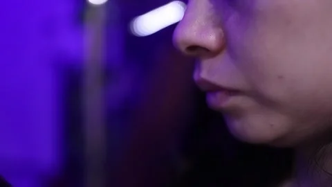 Close-up of Woman Using Smartphone Under Dramatic Purple Lighting Indoors Stock Footage 338024714