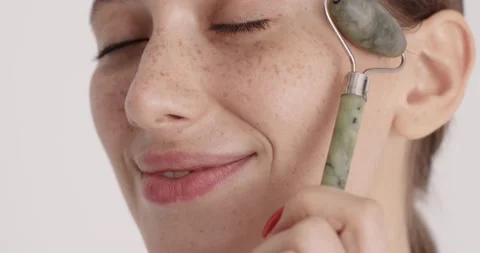 Close up of woman using stone roller for massaging face Stock Footage 171629766