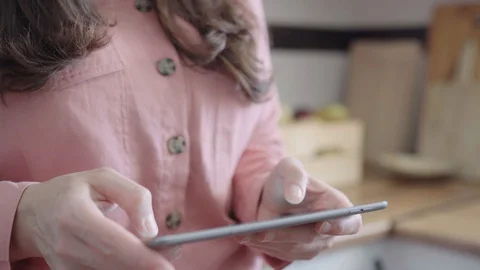 Close up of woman using tablet in her kitchen. Stock Footage 128069824