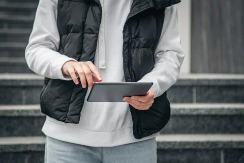 Close-up, a woman is using a tablet outside. Stock Photos
