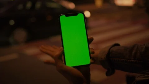 Close-up of woman using vertical smartphone with greenscreen hitchhiking on Stock Footage 117555630