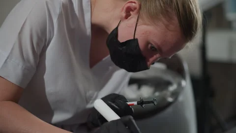 Close up of woman in white coat preparing injection with syringe and vial in Stock Footage 345089716