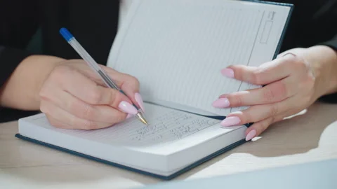 Close up woman writing note in diary at office desk Stock Footage 310808607