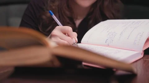 Close Up of Woman Writing in Notebook with Visible Handwriting on Page Stock-Footage 310698500