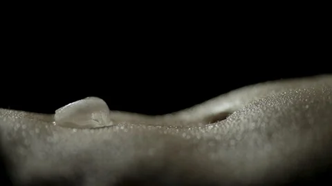 Close-up of a woman's bare belly laying down with a melting ice cube Stock Footage 102839580