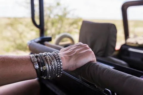 Close up of woman's bracelet jewelry in safari vehicle Stock Photos
