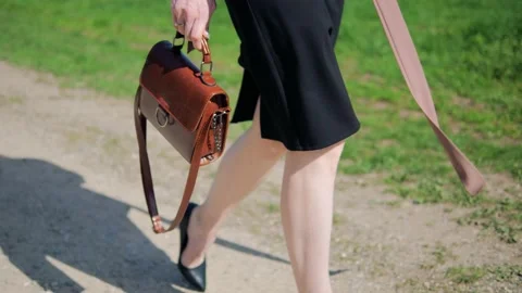 Close-up of a woman's brown handbag in the hands of a walking woman Stock Footage 167645332