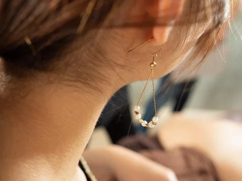A close-up of a woman's ear with a piercing Stock Photos