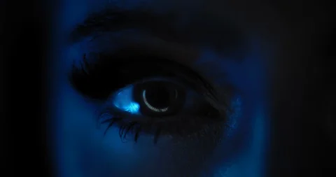 Close up of a woman's eye with beautiful make up opening in a dark blue light Stock Footage 122395701