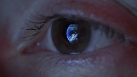 Close up of woman's eye with the earth reflecting in the iris Stock Footage 92063001