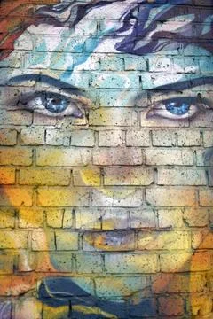 Close-up of a woman's face on a brick wall, street art Stock Photos